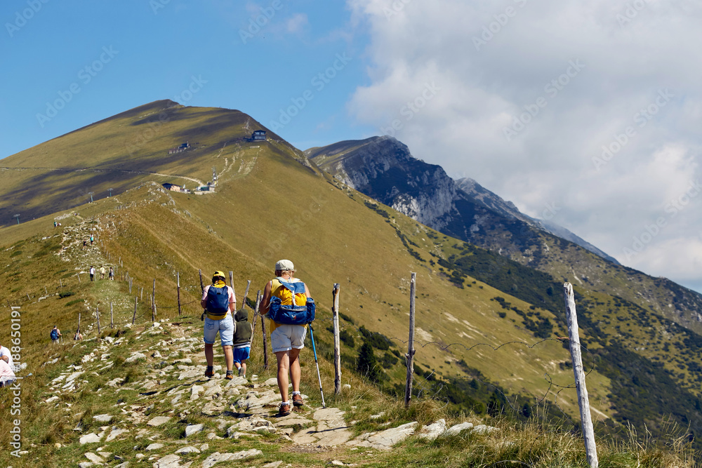 Mount Baldo, Italy - August 15, 2017: Walking family climbing the mountain.
