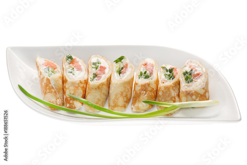 Rolls of thin pancakes with smoked salmon, horseradish cream cheese and rocket leaves