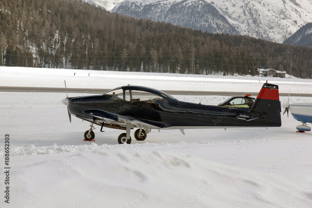 Obraz premium A view of a propeller airplane in the snow covered landscape in the alps switzerland