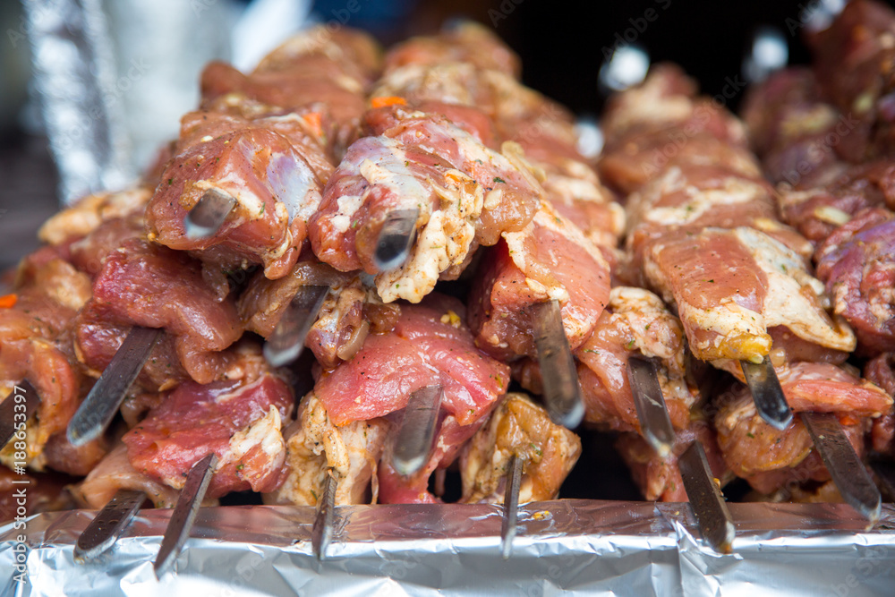 Raw meat and potatoes prepared for frying on skewers.