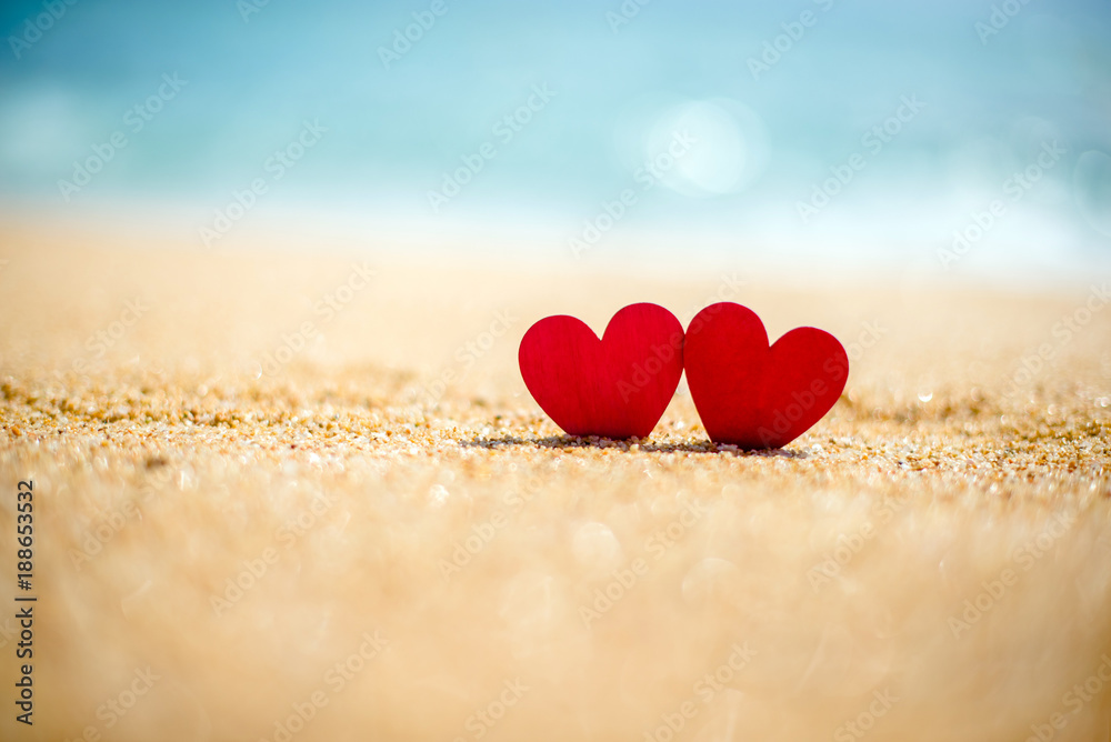 Fototapeta premium romantic symbol of two hearts on the beach 