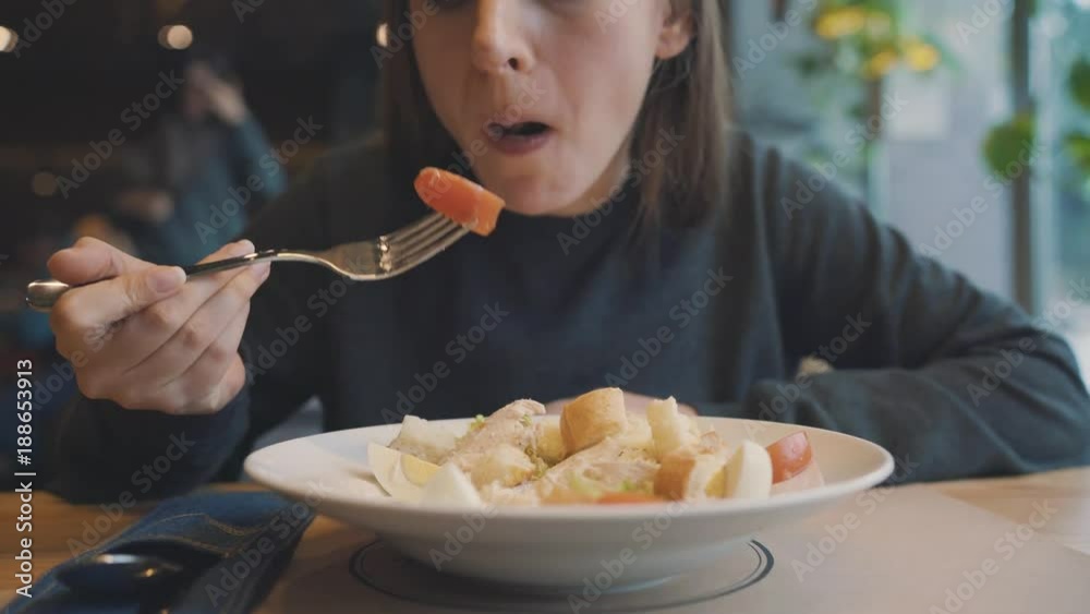 Woman eating caesar salad in a cafe Woman eating caesar salad in a cafe