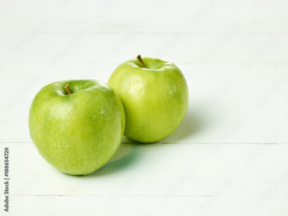 Shot of two fresh green apples with green leaf on a table. Shot of two fresh green apples with green leaf on a table.