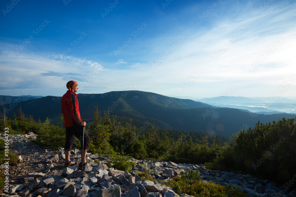 Fototapeta premium Traveler stands on a stony mountain range