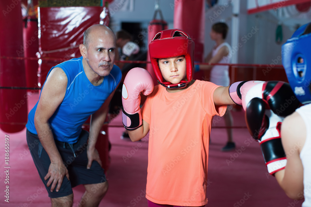 Obraz premium Girl teenage sparring at boxing workout with coach