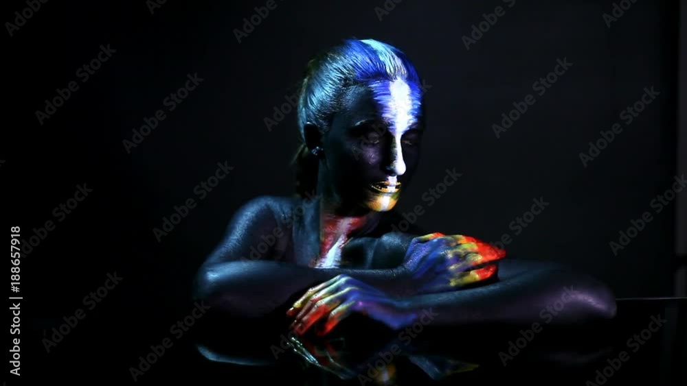 Body art portrait of a dark-skinned glowing girl with color make-up Body art portrait of a dark-skinned glowing girl with color make-up