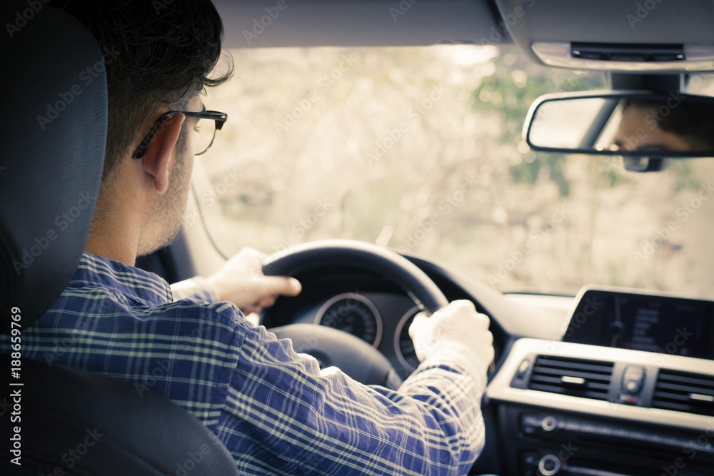 young man driving behind the wheel of the car