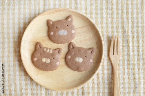 Three Pieces of Homemade Chocolate Cookies Cat Face in Wooden Plate and Folk 