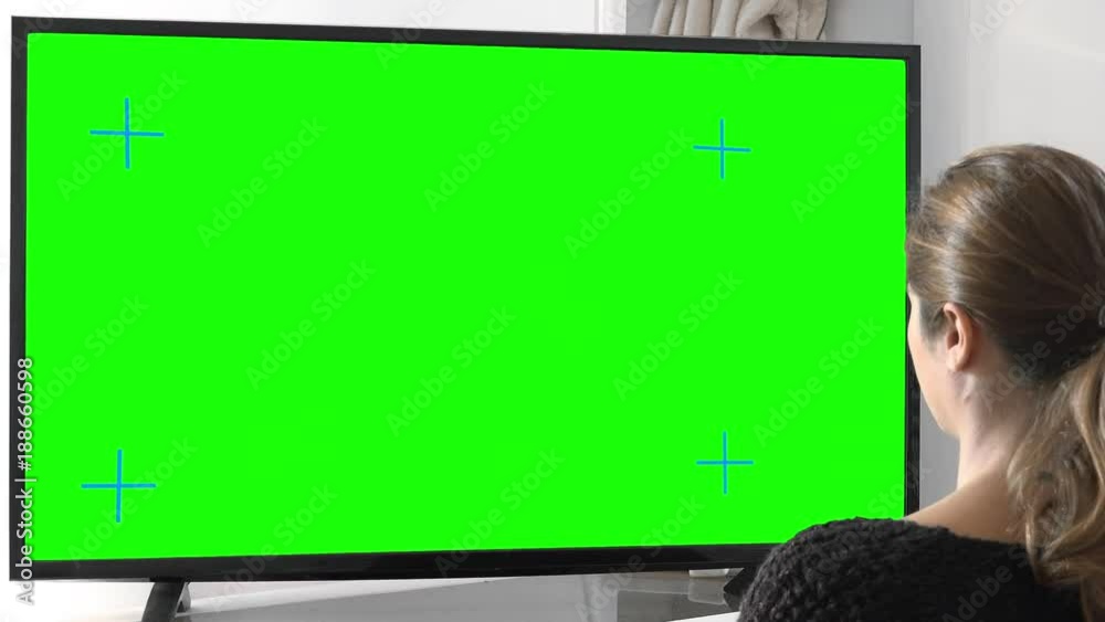 Girl Watching Tv Green Screen Zoom Out. Zoom out young woman watching green screen television at