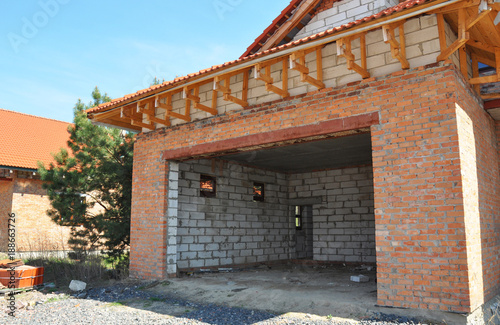 Building construction new unfinished  house garage.  Roofing and insulation brick wall garage.