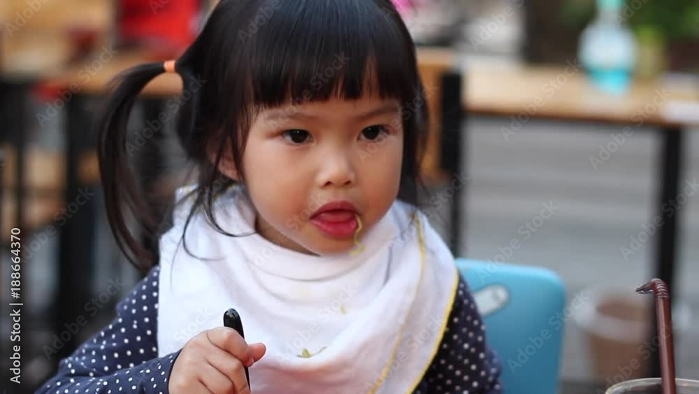 little asian girl eating noodles. little asian girl eating noodles.