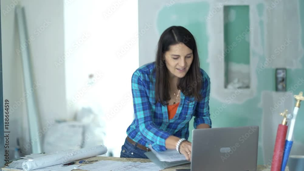 Happy woman with blueprints and laptop finishing work and leaving her new home
Happy woman with blueprints and laptop finishing work and leaving her new home