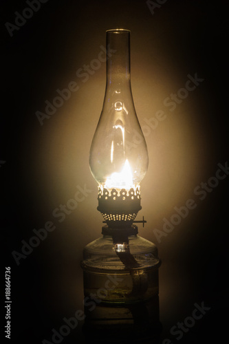 Glowing antique old kerosene oil lamp with vintage glass chimney