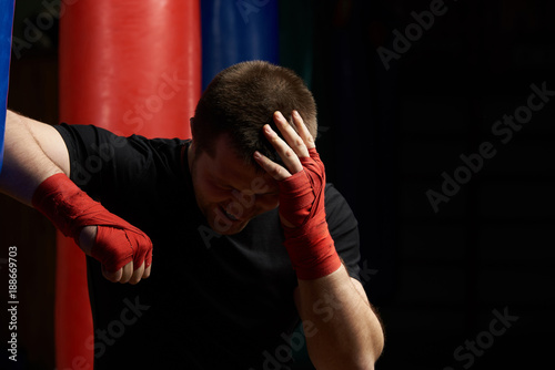 Boxing man holding head in pain