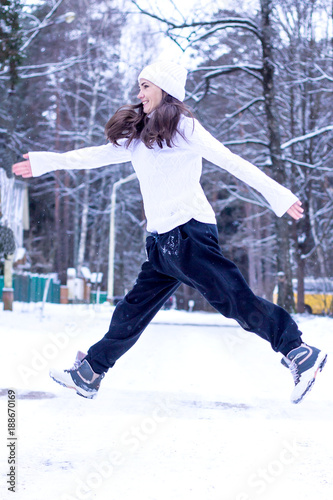 Young woman having fun outdoors, jumping, winter, snow outside