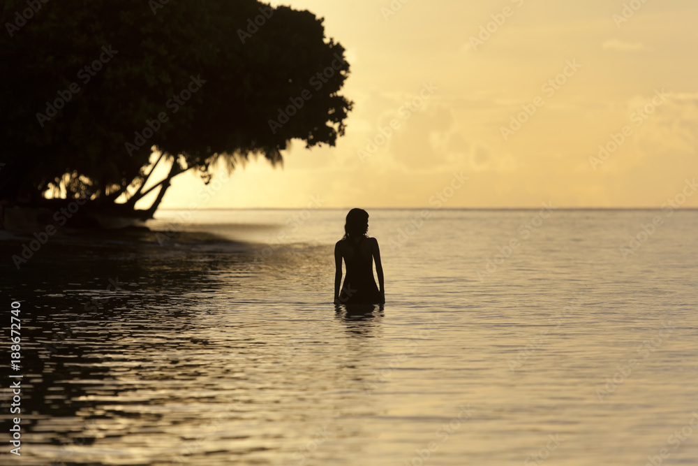 Maledivenstrand am Abend mit badenden Mädchen