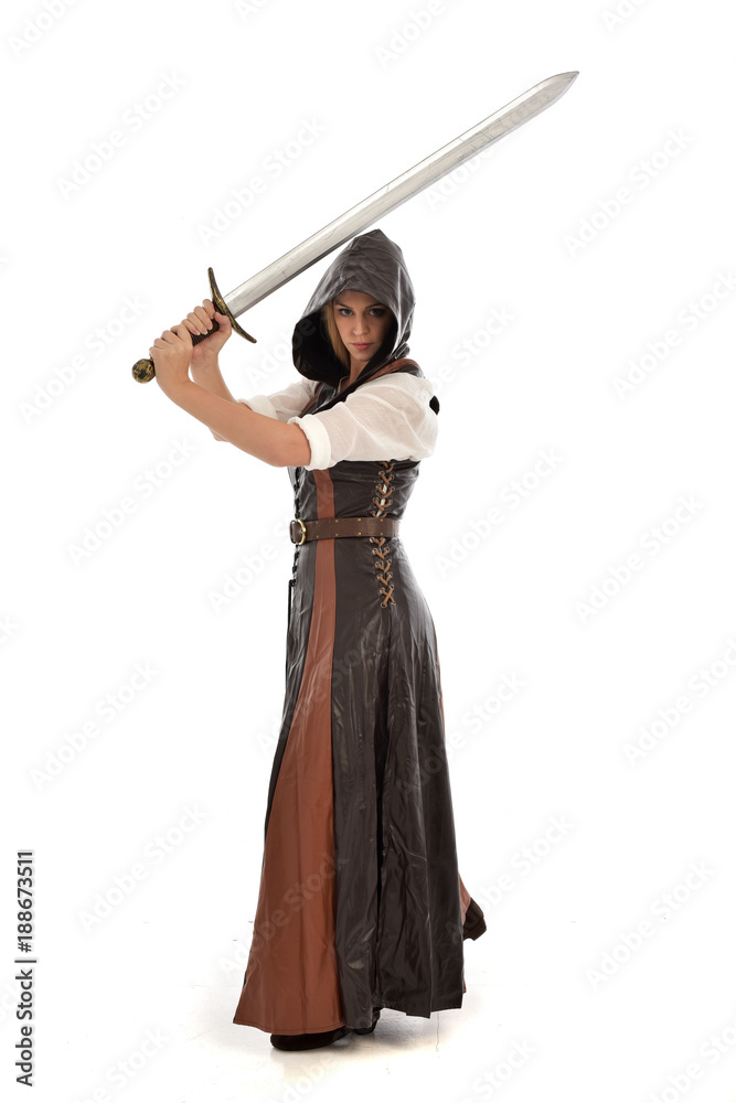 full length portrait of girl wearing brown fantasy costume, holding a sword. standing pose on white studio background. full length portrait of girl wearing brown fantasy costume, holding a sword. standing pose on white studio background.