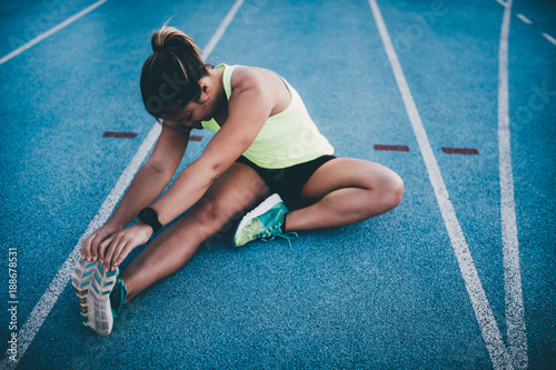 Female athletic woman stretching after running workout photo