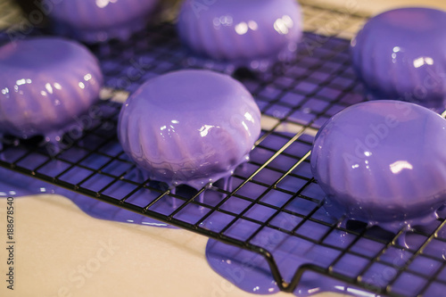 The purple icing on the cakes. Modern French mousse desserts with mirror glaze. Picture for a menu or a confectionery catalog. photo