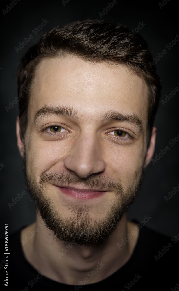 Portrait of a young man with a beard on a dark background. Portrait of a young man with a beard on a dark background.