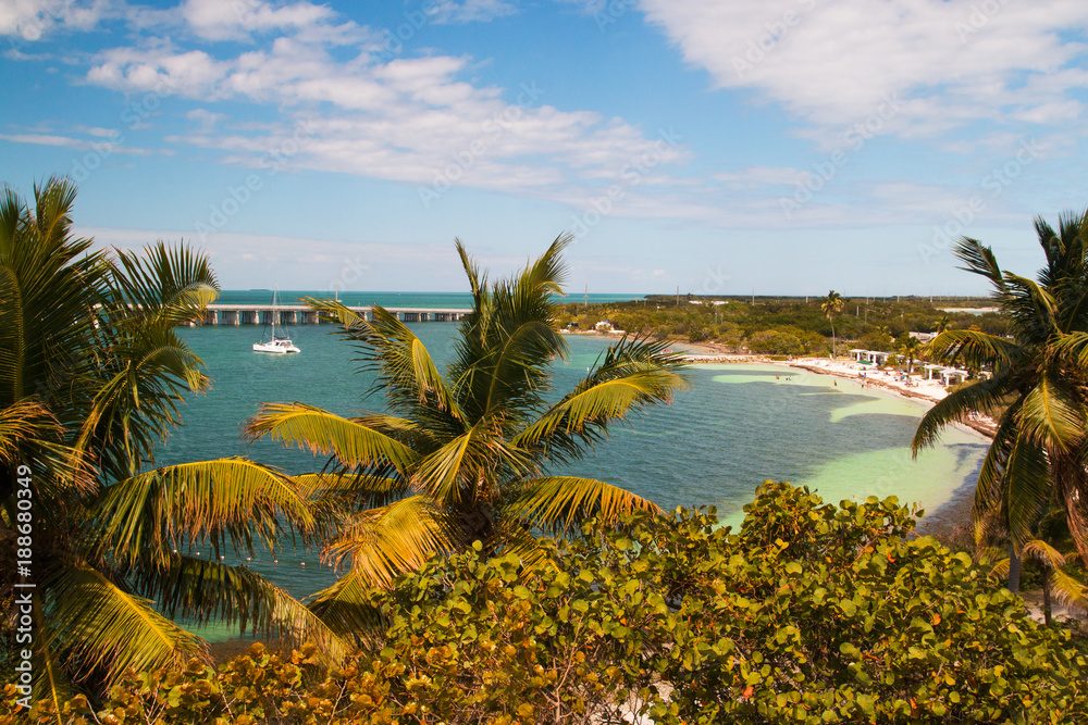 Florida holidays destination scenery, Bahia Honda State Park bay, 12 mile bridge and beach coast of turquoise tropical lagoon with docked yacht, palm trees and sea grape in front