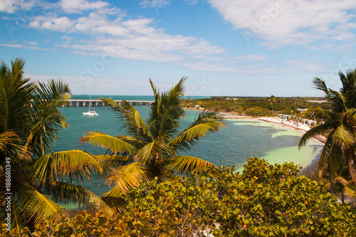 Florida holidays destination scenery  Bahia Honda State Park bay  12 mile bridge and beach coast of turquoise tropical lagoon with docked yacht  palm trees and sea grape in front