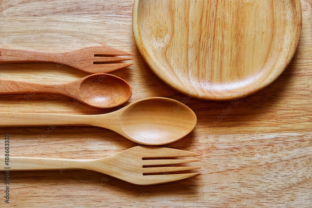 Top view, Wooden spoons, forks and wooden plate or dish on the wooden table Top view, Wooden spoons, forks and wooden plate or dish on the wooden table