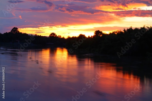 Soft focus of colorful dramatic sky with reflection on river © Karntipas