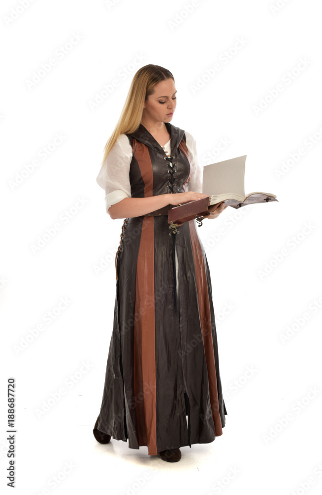 full length portrait of girl wearing brown fantasy costume, holding a book. standing pose on white studio background. full length portrait of girl wearing brown fantasy costume, holding a book. standing pose on white studio background.