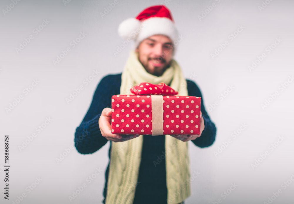 Handsome man in a Christmas hat holding gifts on white background Handsome man in a Christmas hat holding gifts on white background