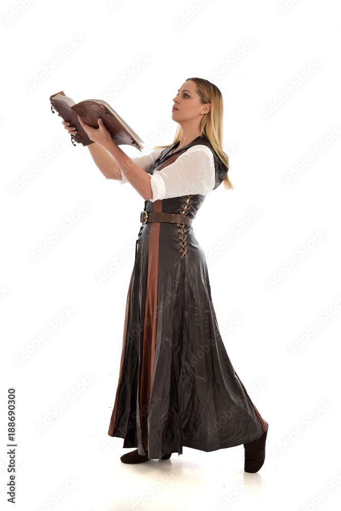 full length portrait of girl wearing brown fantasy costume, holding a book. standing pose on white studio background. full length portrait of girl wearing brown fantasy costume, holding a book. standing pose on white studio background.