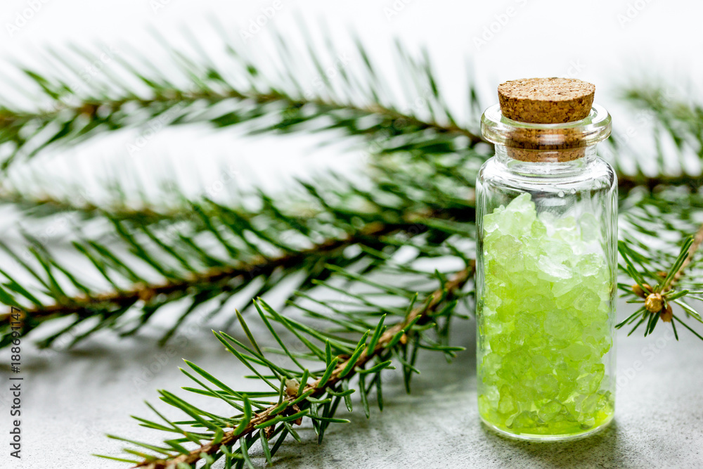 Bottles of sea salt and fir branches for aromatherapy and spa on