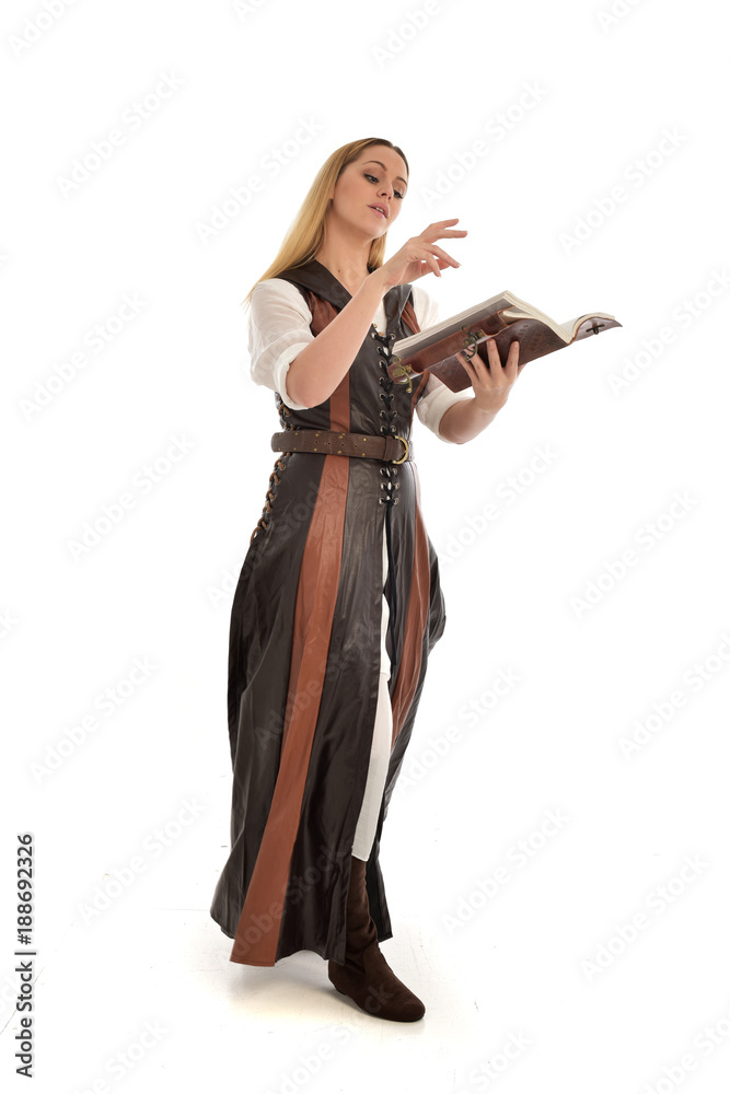 full length portrait of girl wearing brown fantasy costume, holding a book. standing pose on white studio background. full length portrait of girl wearing brown fantasy costume, holding a book. standing pose on white studio background.