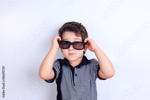 Lovely little boy in sunglasses, studio shoot on white. Children, fashion and lifestyle concept