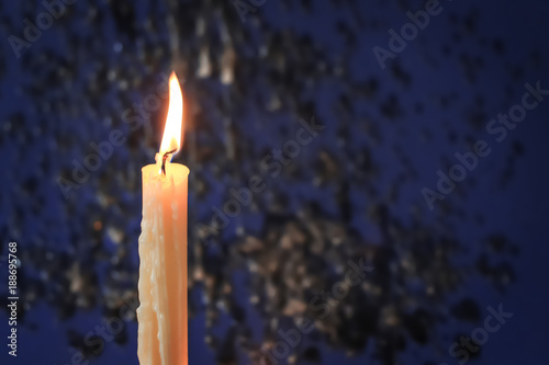 Burning candle on color background