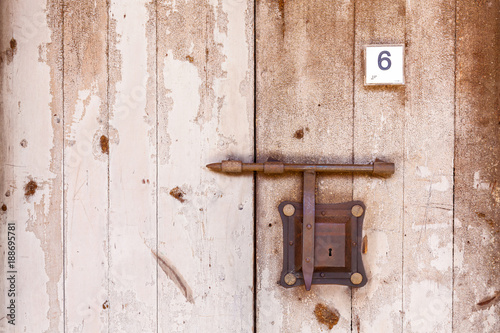 Wooden antique door with lock bolt. Ancient door.