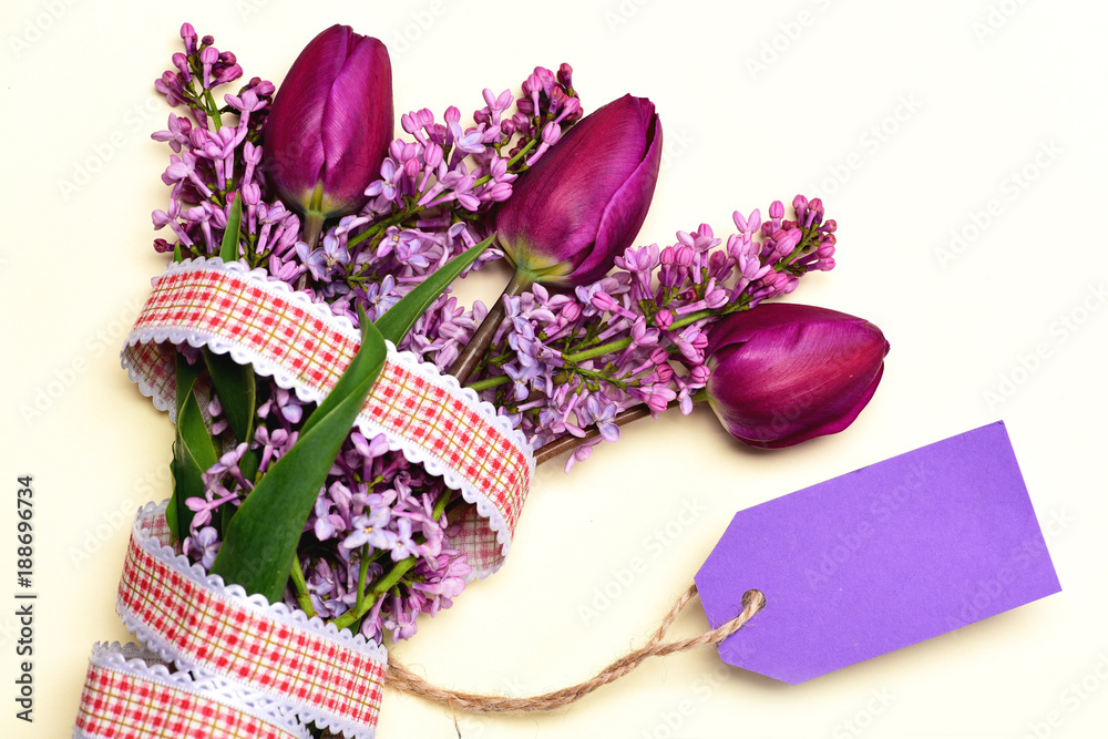 Naklejka premium Tulips and lilac flowers with rustic ribbon and price tag