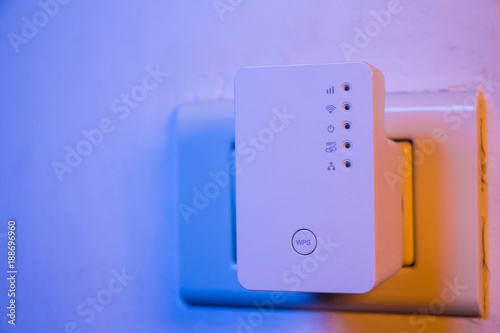 WiFi repeater in electrical socket on the wall photo
