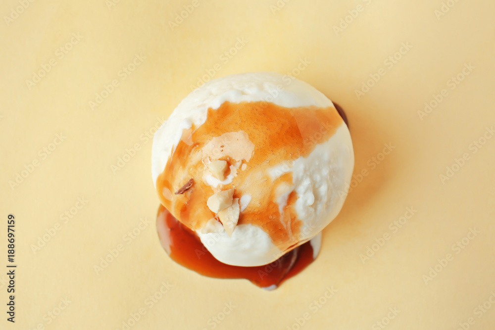Ice cream ball with caramel sauce on color background Ice cream ball with caramel sauce on color background