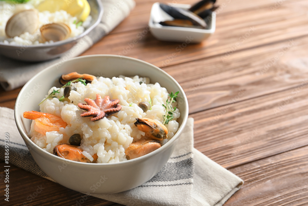 Dish with delicious seafood risotto on wooden table Dish with delicious seafood risotto on wooden table