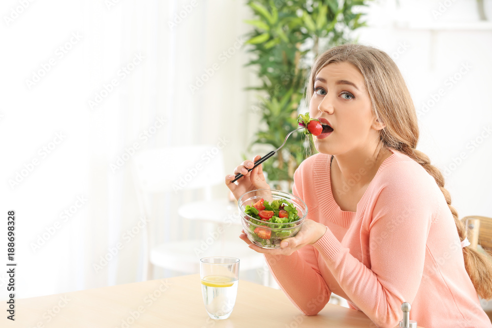Young beautiful woman eating fresh salad at home Young beautiful woman eating fresh salad at home