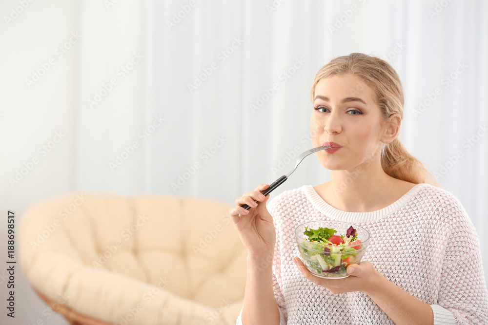 Young beautiful woman eating fresh salad at home Young beautiful woman eating fresh salad at home