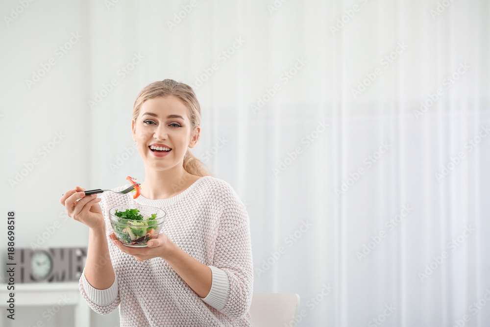 Young beautiful woman eating fresh salad at home Young beautiful woman eating fresh salad at home