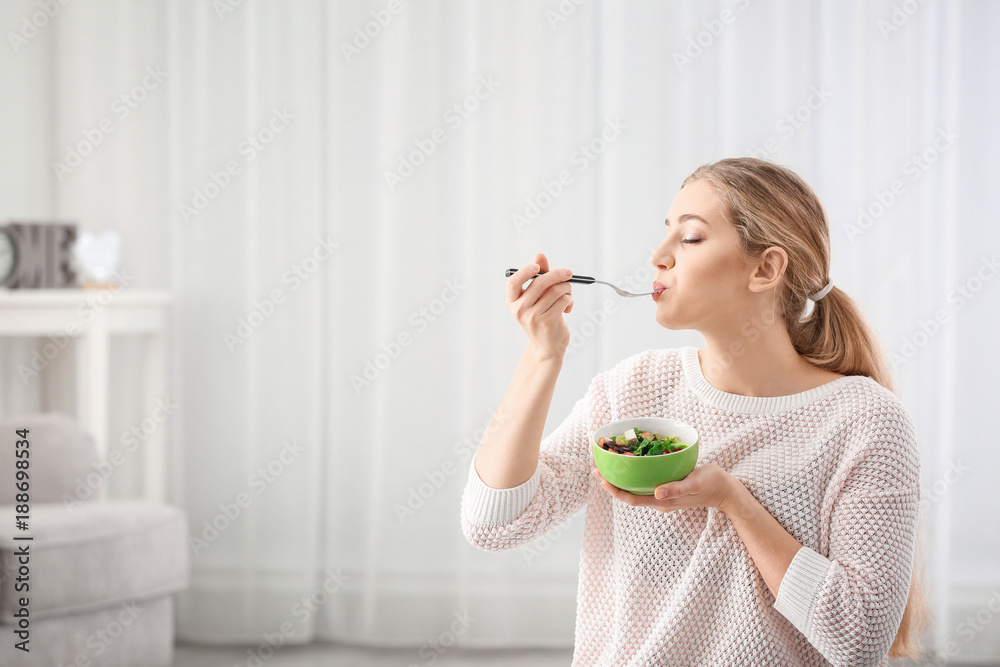 Young beautiful woman eating fresh salad at home Young beautiful woman eating fresh salad at home