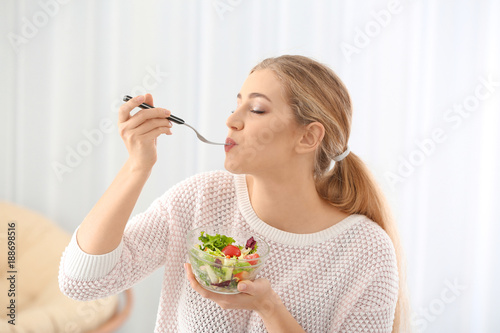 Young beautiful woman eatin...
