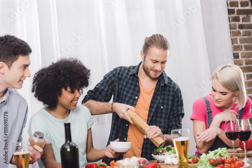 man adding spice to food with pepper grinder