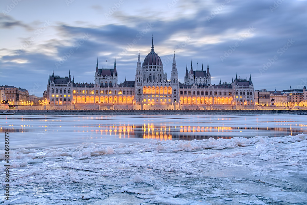 Naklejka premium Zimowy zmierzch widok budynku parlamentu w Budapeszcie nad zamarzniętym Dunajem