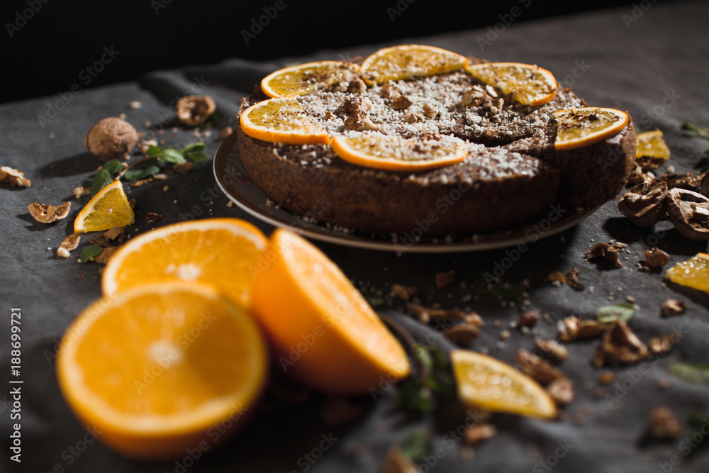 Beautiful and tasty chocolate cake with orange and nut on a dark background