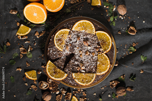 Beautiful and tasty chocolate cake with orange and nut on a dark background © alexbutko_com