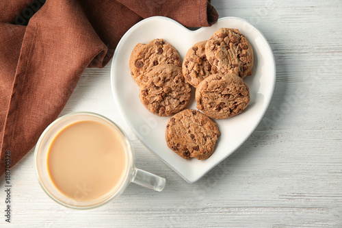 Plate with delicious oatmeal cookies and cup of coffee on table